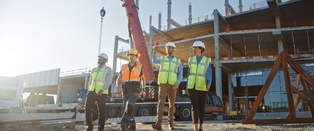 Commercial construction workers on the construction site discussing the commercial construction process.